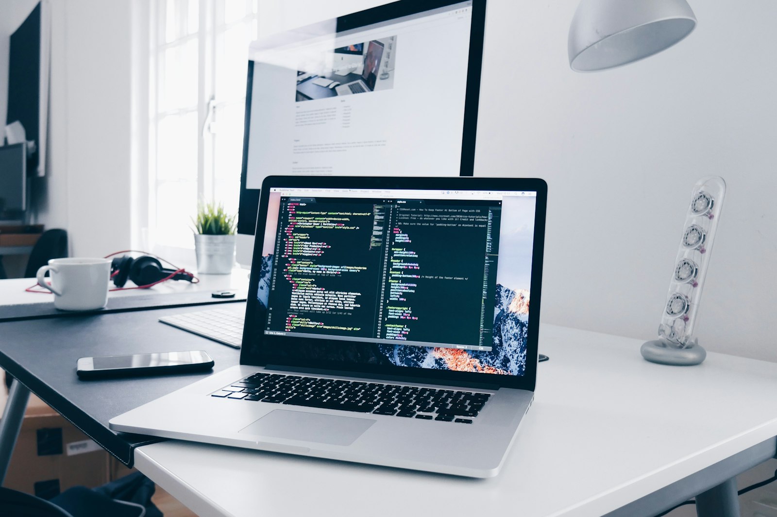 Laptop showing code on a white desk