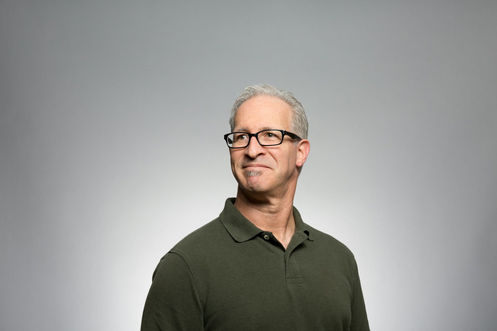 Older man with glasses in olive polo shirt