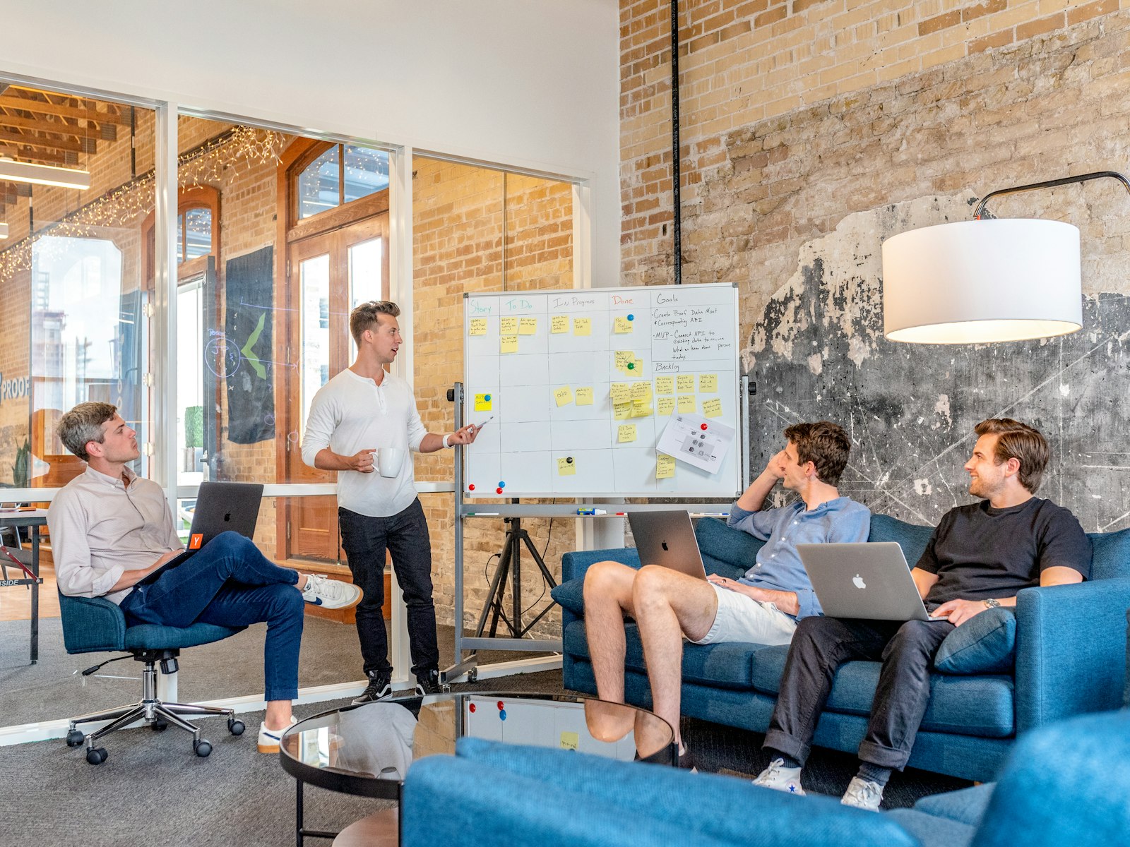 Colleagues around a whiteboard in a brick loft office