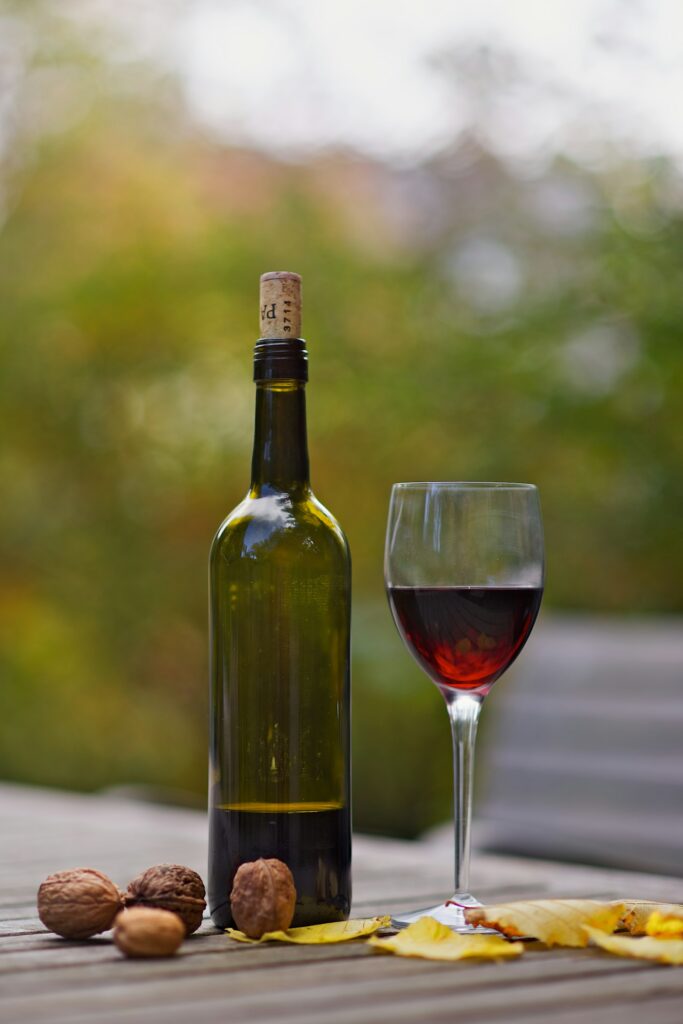Wine bottle and glass of red wine outdoors